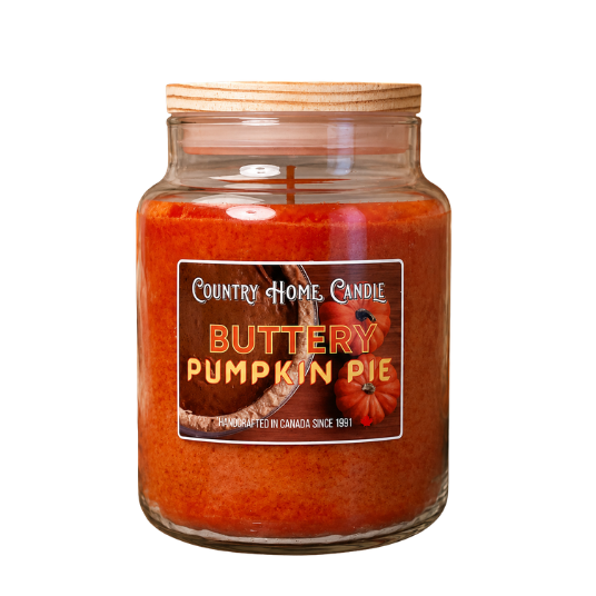 A Country Home Candle in a clear glass jar with a light wood lid, filled with orange pumpkin pie scented wax. The front features a label with the brand name 'Country Home Candle' and the scent 'Butterly Pumpkin Pie' alongside illustrations of pumpkins.