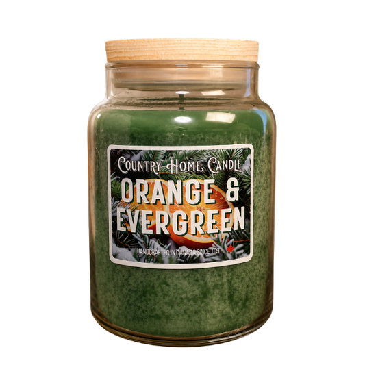 A large glass jar candle with green wax and a light wood lid, featuring a front label that reads 'Country Home Candle Orange & Evergreen' on a white background.