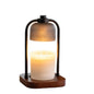 A floating candle lamp with a frosted glass shade hovering above a lit white candle in a wooden base, set against a plain white background.